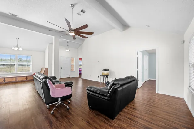 a living room with furniture and a wooden floor