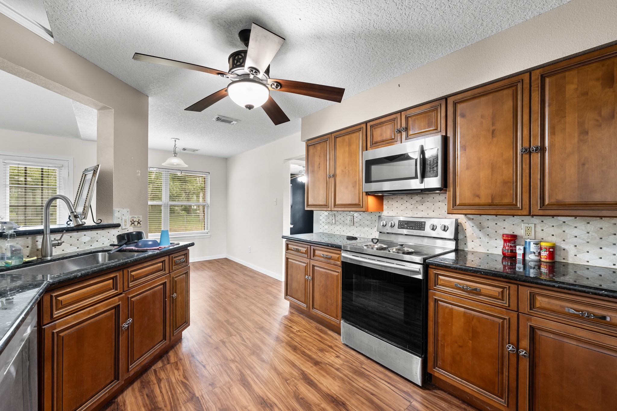 7442 County Road 42 Rosharon, TX 77583 - Photo 15 of 43 a kitchen with stainless steel appliances granite countertop a stove top oven a sink dishwasher and a microwave oven on the wooden floor