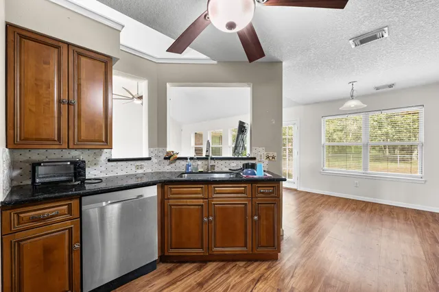 a kitchen with a sink a window and cabinets