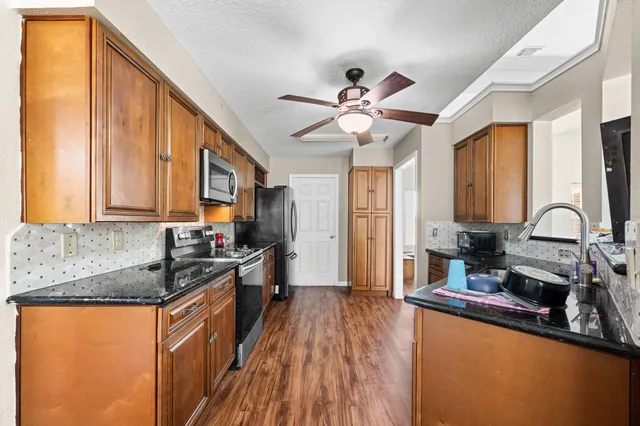 a kitchen with stainless steel appliances granite countertop a sink stove and refrigerator