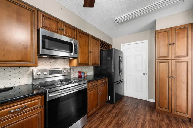 a kitchen with stainless steel appliances a refrigerator sink and microwave