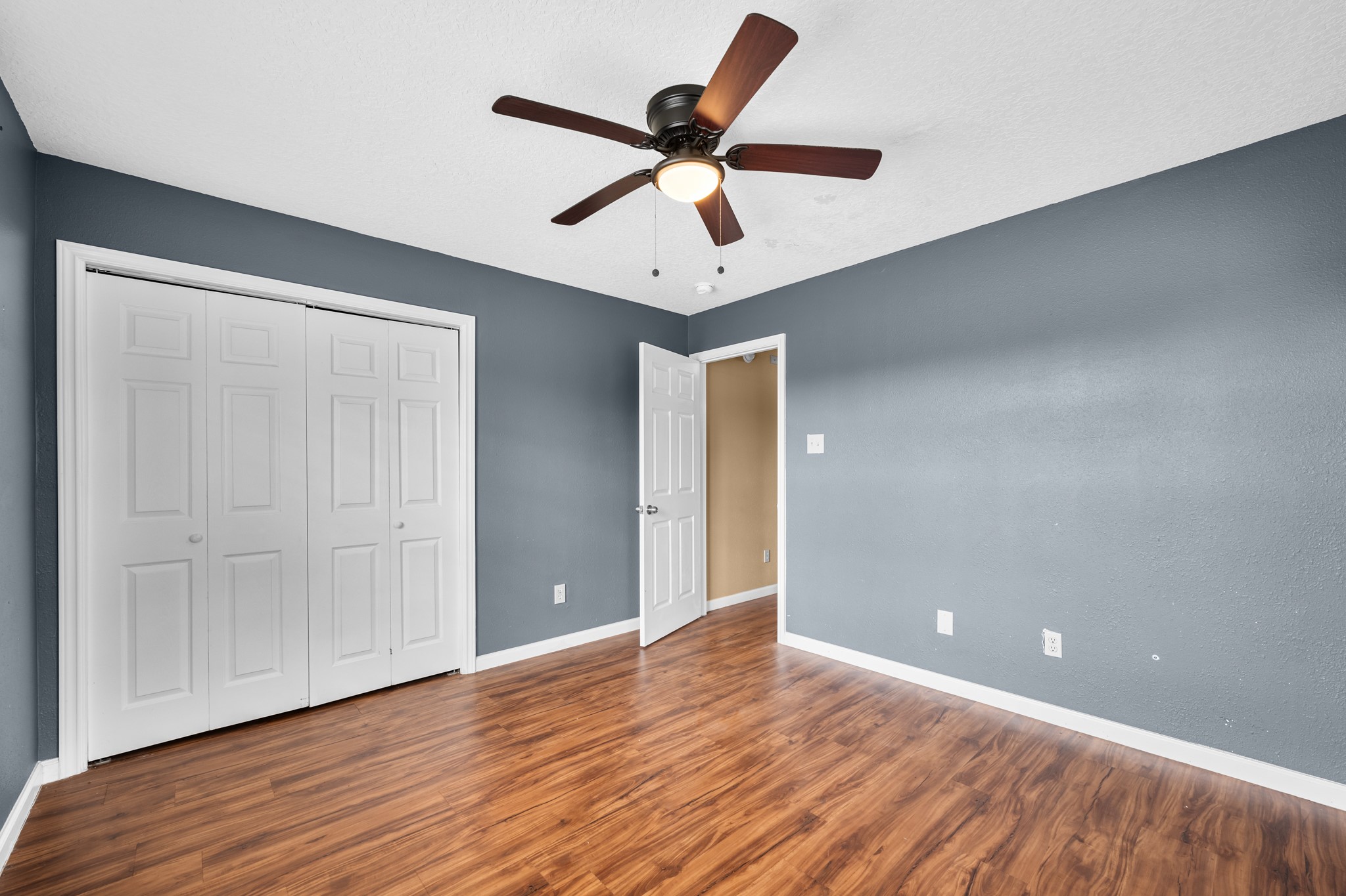7442 County Road 42 Rosharon, TX 77583 - Photo 29 of 43 an empty room with wooden floor and ceiling fan