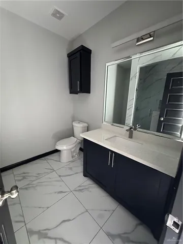 a bathroom with a double vanity sink mirror and toilet