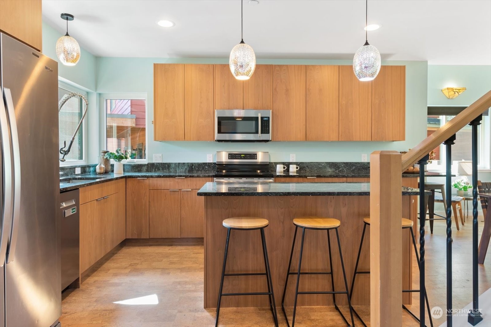 1402 194th Street Southeast, Unit 4 Bothell, WA 98012 - Photo 5 of 40 a kitchen with stainless steel appliances granite countertop a refrigerator a sink dishwasher a stove and a dining table with wooden floor