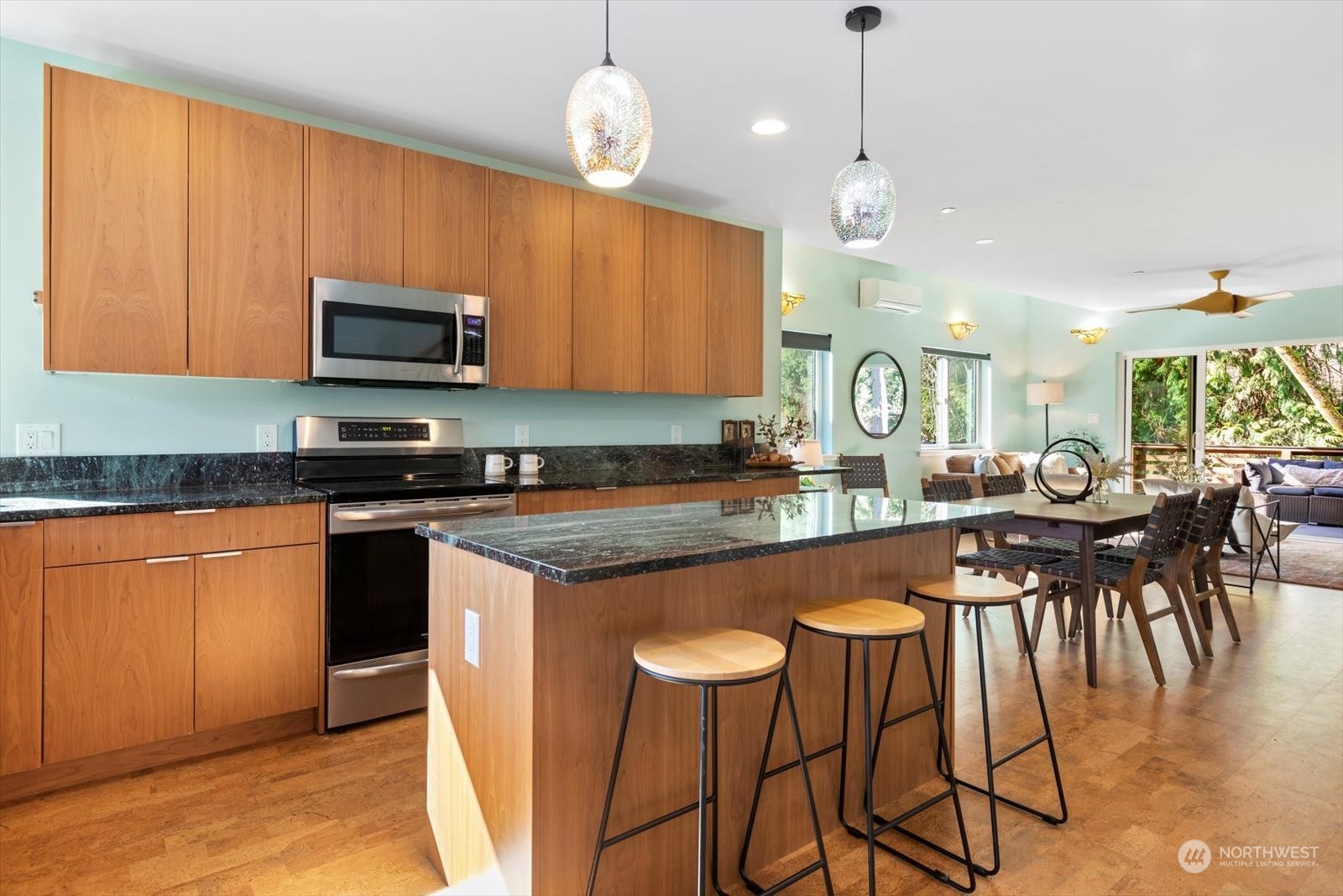 1402 194th Street Southeast, Unit 4 Bothell, WA 98012 - Photo 6 of 40 a kitchen with stainless steel appliances granite countertop a stove top oven a sink a dining table and chairs with wooden floor