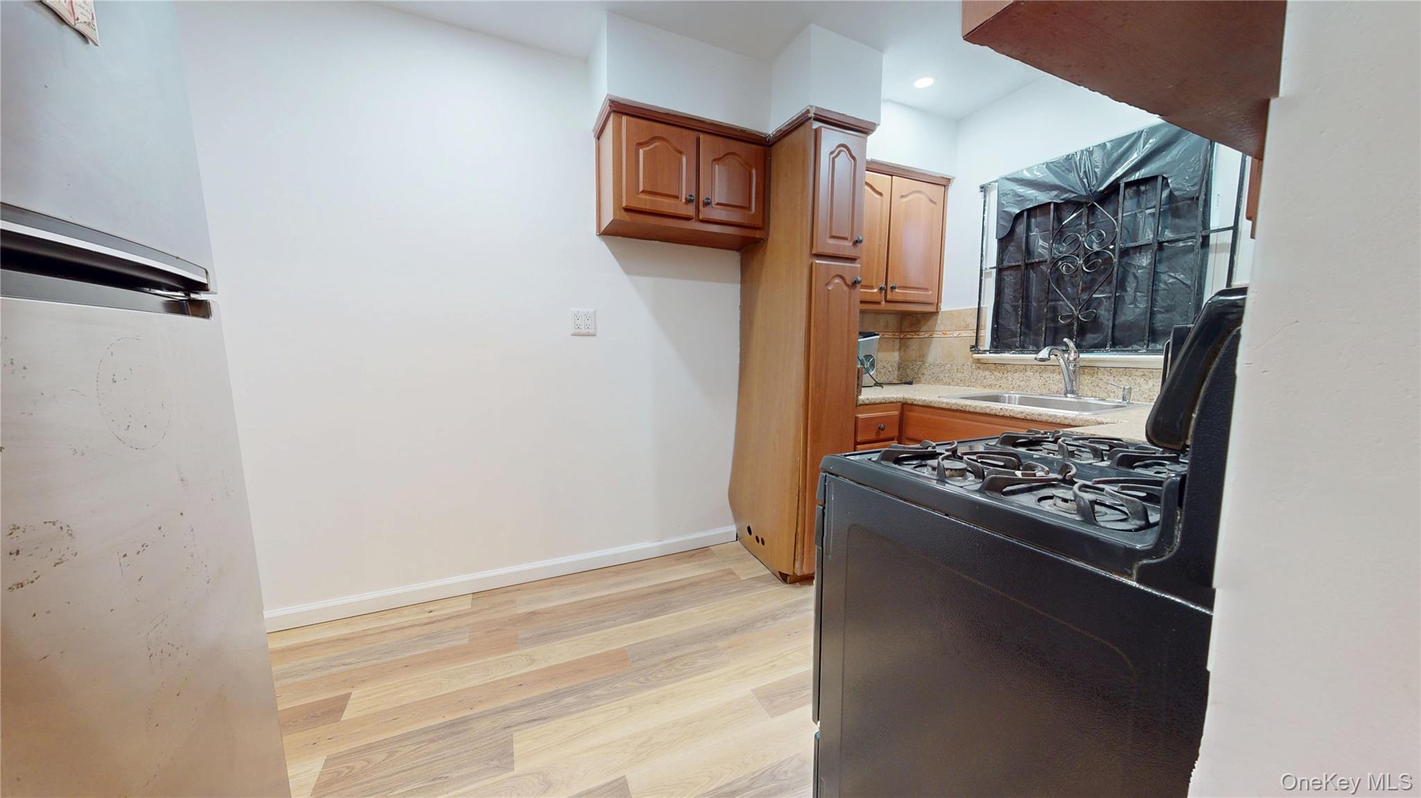 219-42 141st Road Queens, NY 11413 - Photo 16 of 23 a view of kitchen island with stainless steel appliances wooden floor and a refrigerator