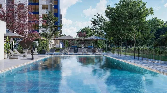a view of pool with table and chairs under an umbrella