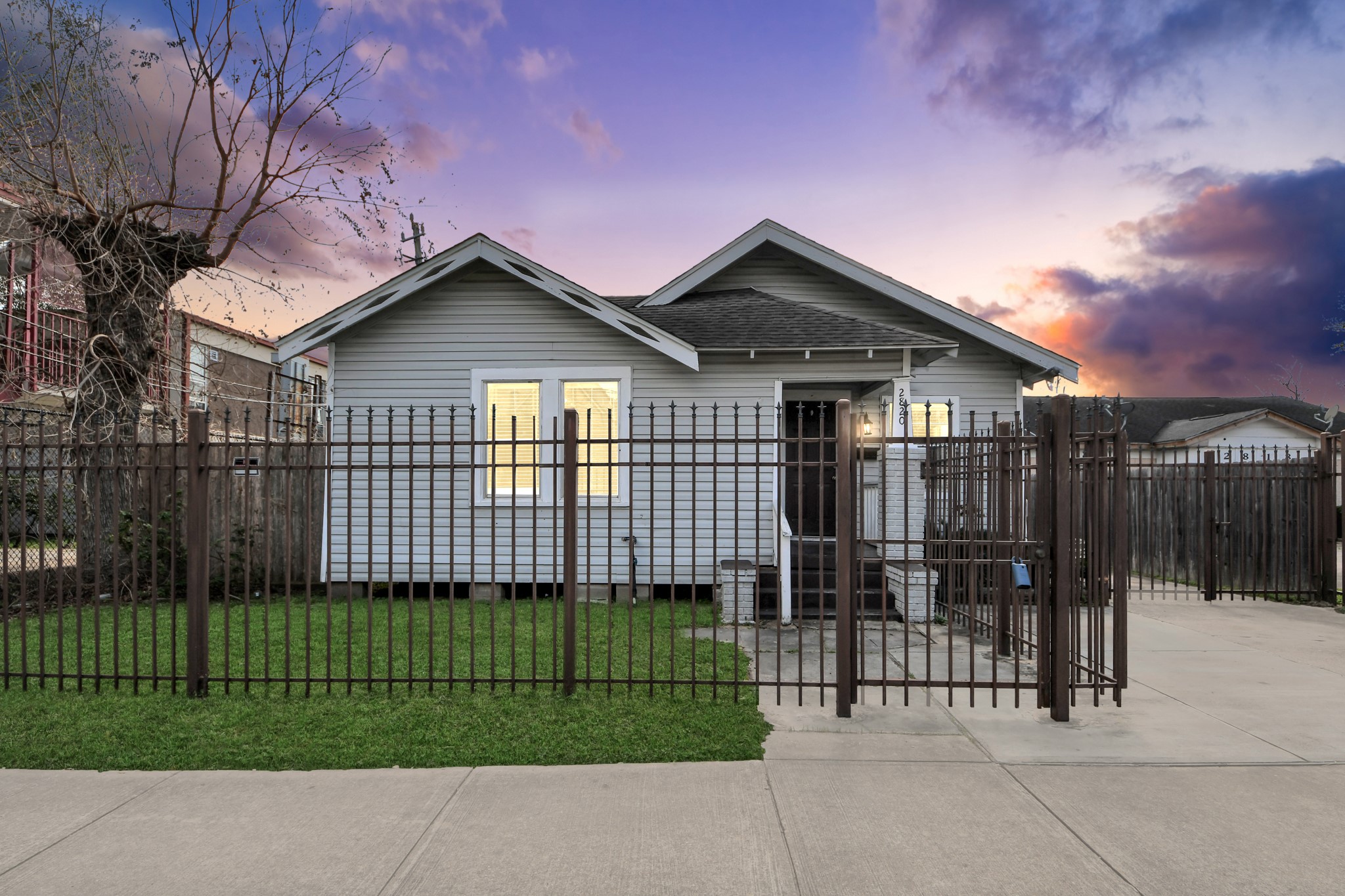 Charming single-story home featuring a cozy exterior with a fully fenced yard, well-maintained lawn, and a paved driveway.
