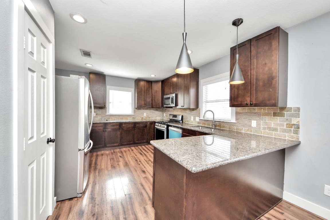 2820 Holman Street Houston, TX 77004 - Photo 15 of 38 a kitchen with a sink a counter space appliances and cabinets