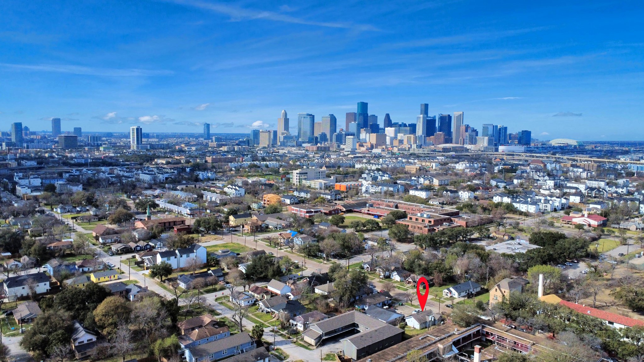 2820 Holman Street Houston, TX 77004 - Photo 38 of 38 This photo shows a charming neighborhood with a red marker indicating the home's location. It's situated near a vibrant city skyline, suggesting convenient urban access while maintaining a suburban feel. The area is dotted with trees and well-maintained homes, offering a blend of city and community living.