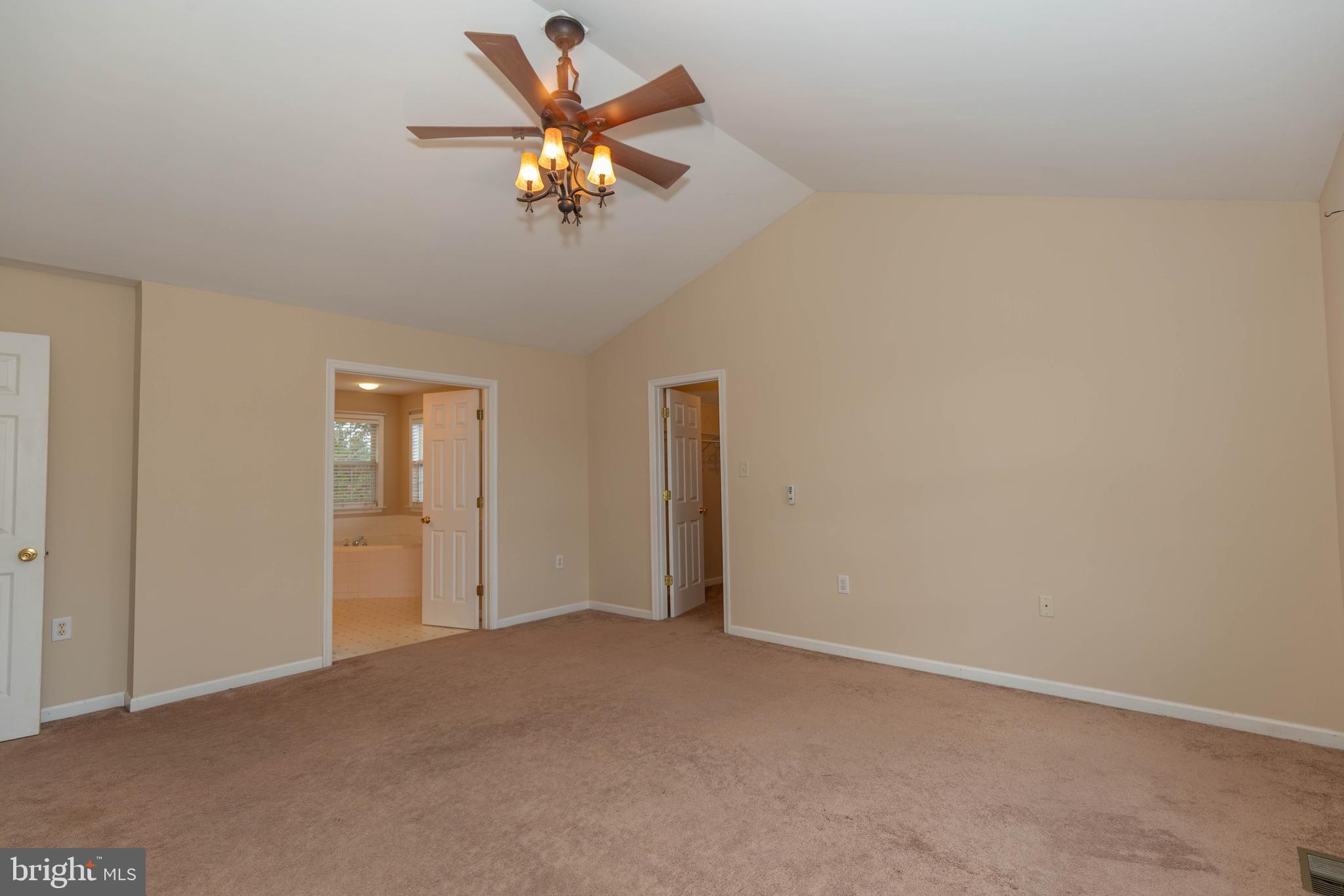 131 Cypress Point Drive Charles Town, WV 25414 - Photo 15 of 35 an empty room with a chandelier fan and windows