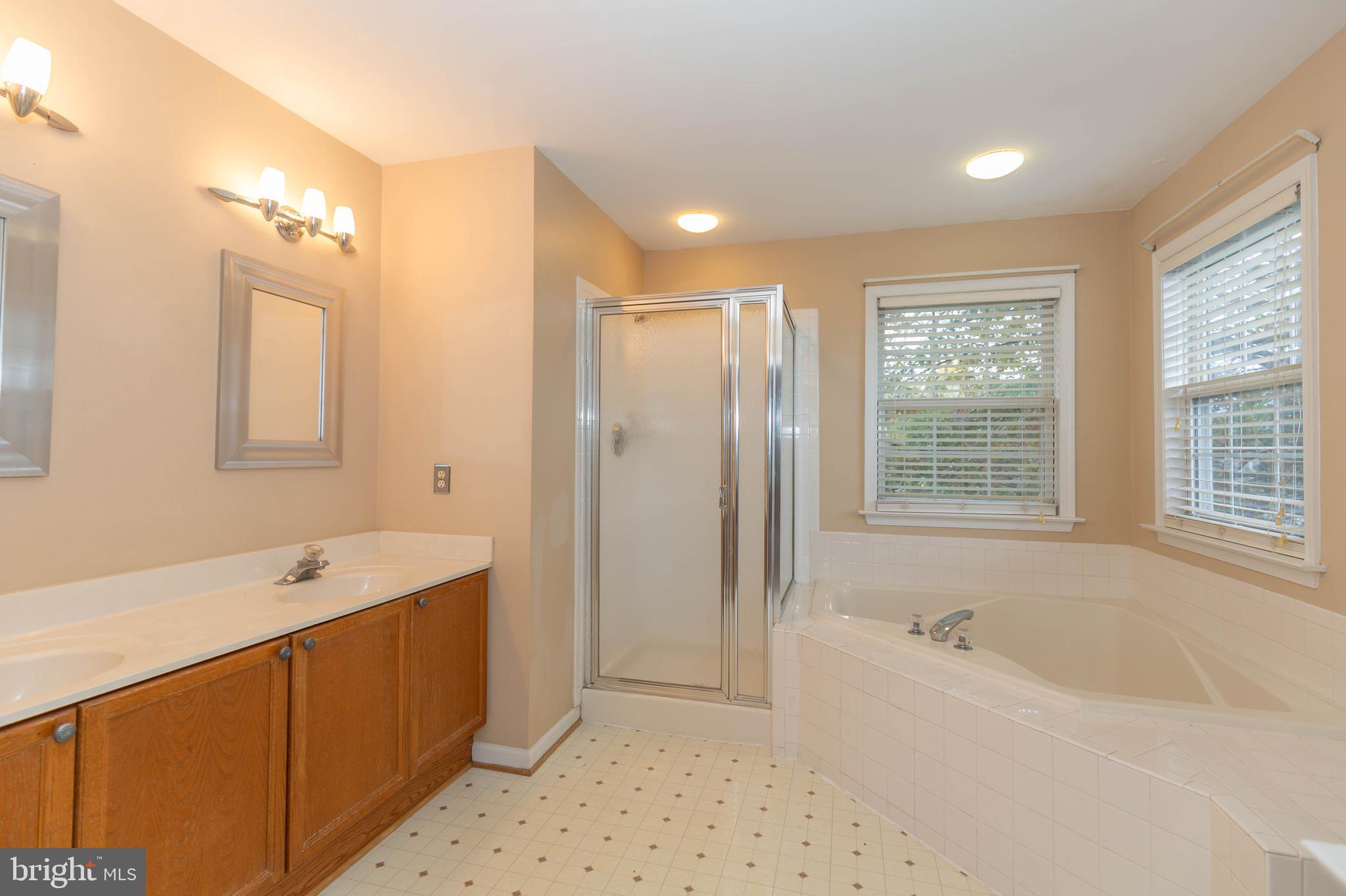 131 Cypress Point Drive Charles Town, WV 25414 - Photo 16 of 35 a spacious bathroom with a bathtub a shower a sink and a window