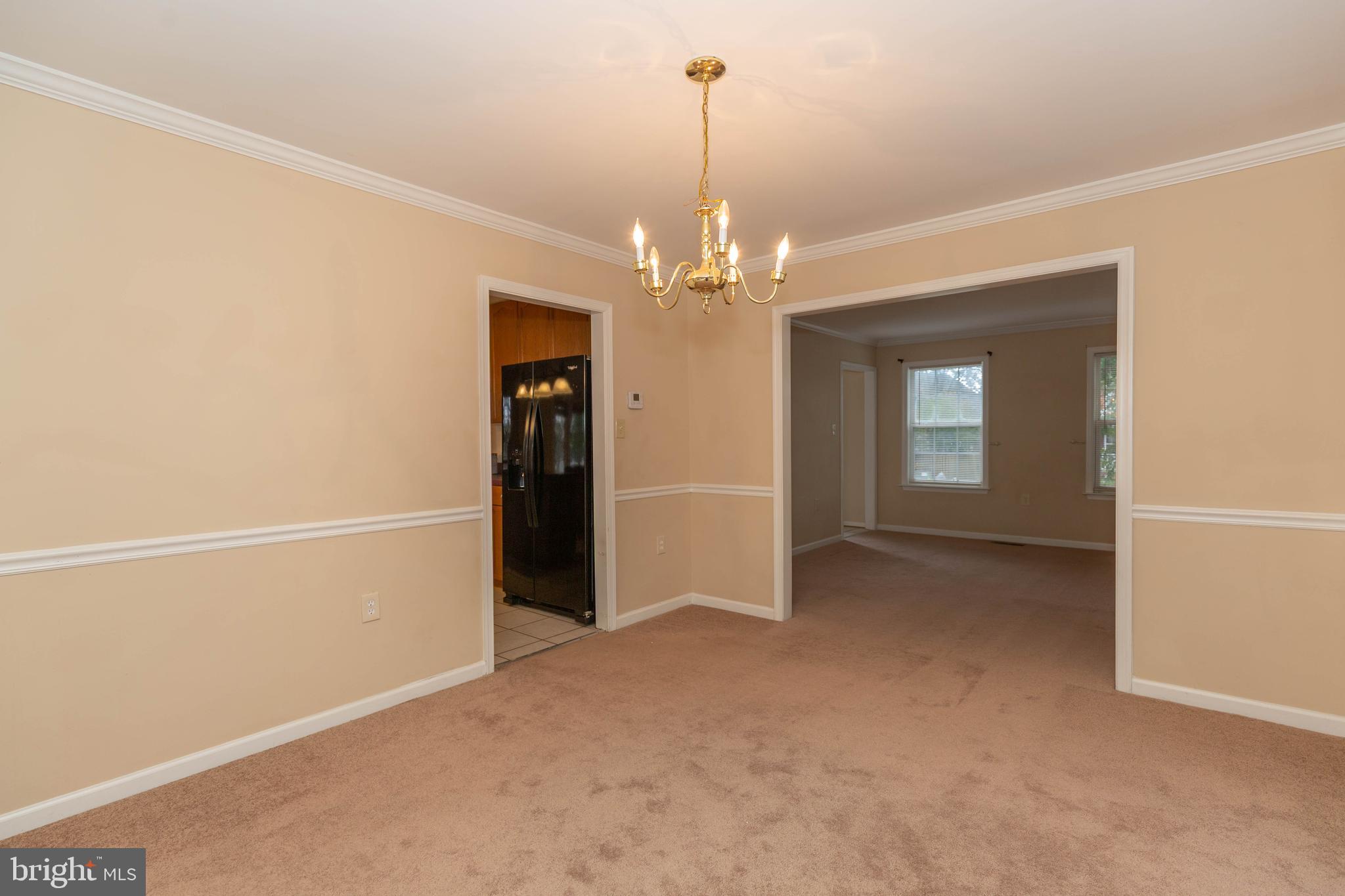131 Cypress Point Drive Charles Town, WV 25414 - Photo 27 of 35 en empty room with chandelier fan and kitchen view