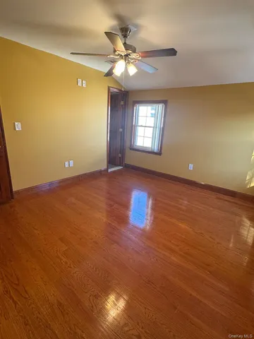 an empty room with windows and ceiling fan