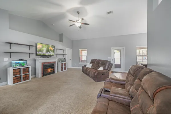 a living room with furniture a fireplace and a flat screen tv