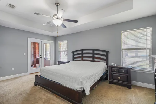 a bedroom with a bed a chandelier and a dresser