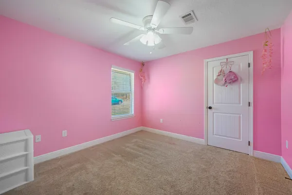 a big room with windows and chandelier fan