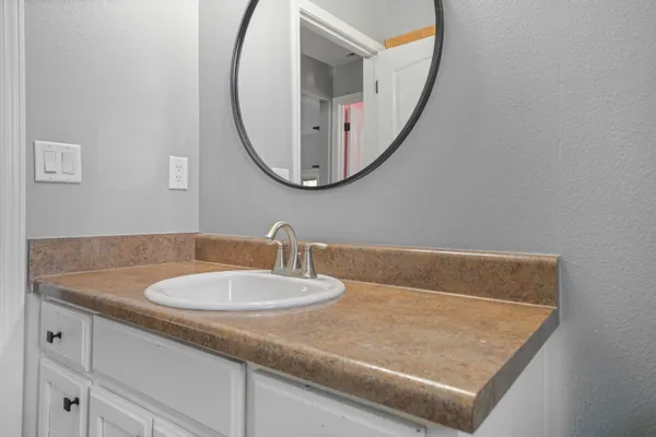 a bathroom with a granite countertop sink and a mirror