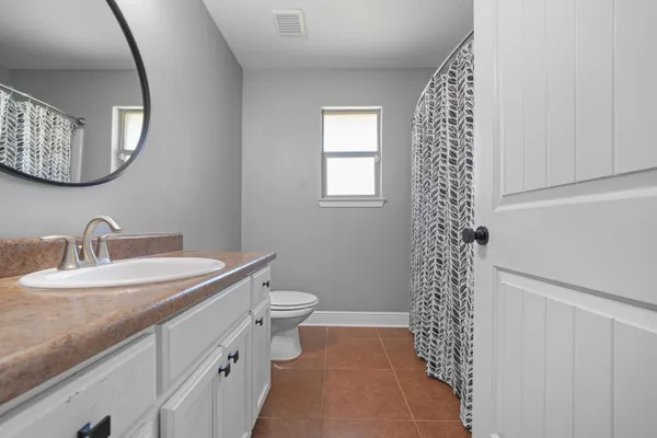 a bathroom with a sink a toilet and a mirror