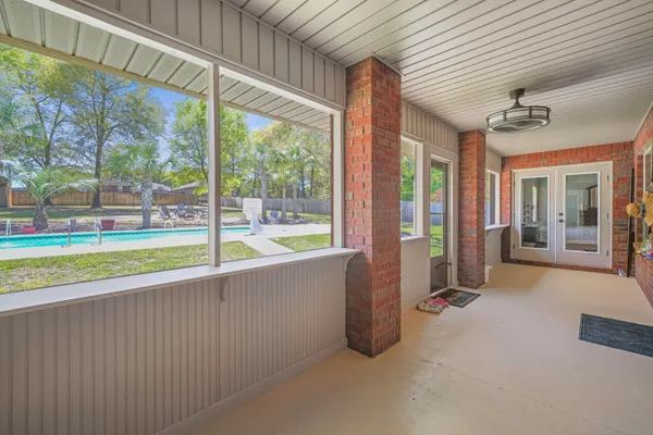 a view of an empty room with a floor to ceiling window and a swimming pool