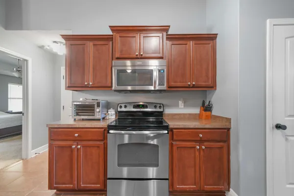 a kitchen with granite countertop a stove top oven microwave and cabinets