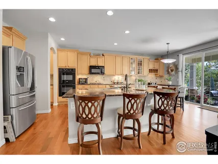 a kitchen with stainless steel appliances a dining table chairs and refrigerator