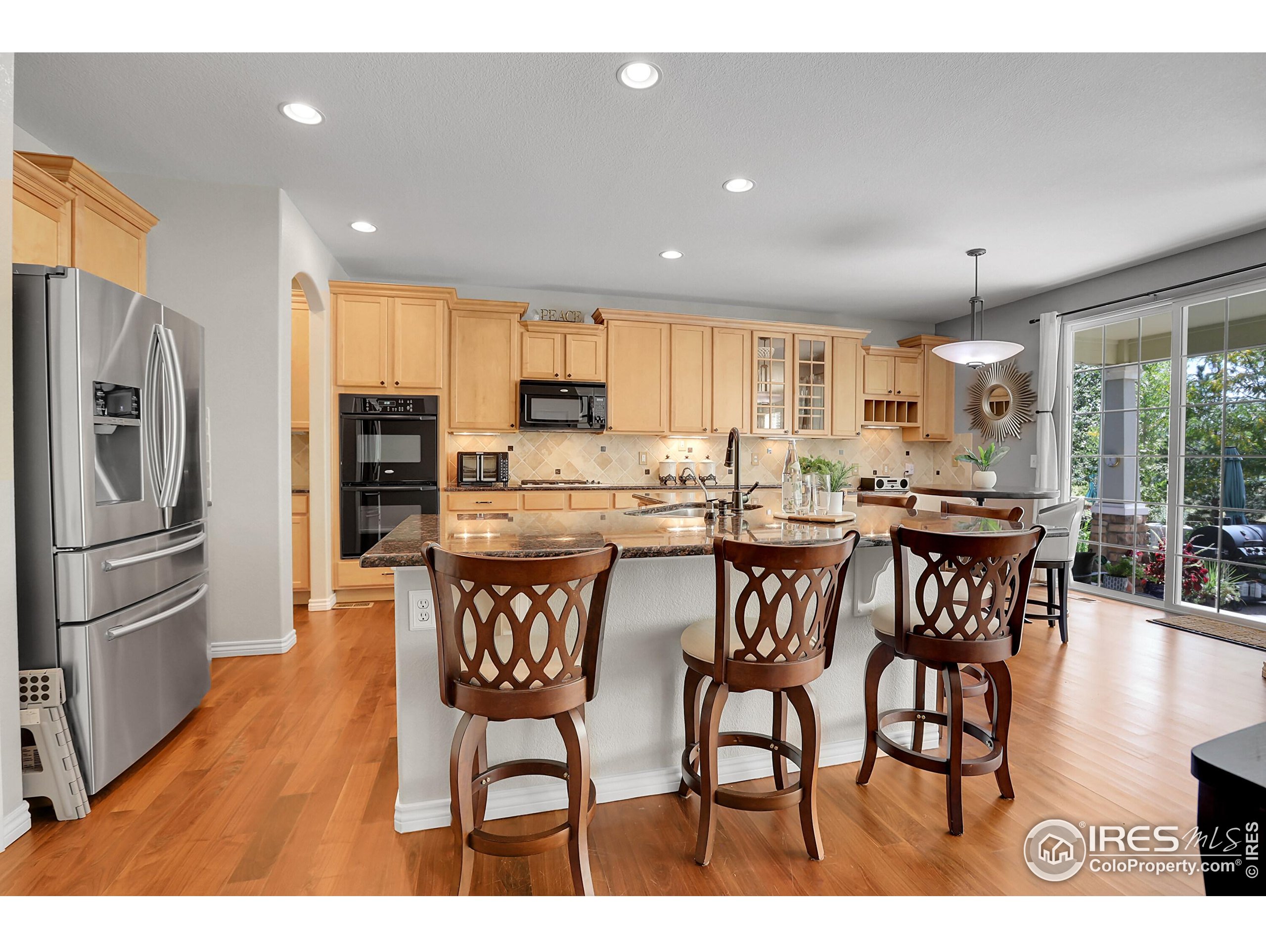 112 Austin Avenue Erie, CO 80516 - Photo 16 of 44 a kitchen with stainless steel appliances a dining table chairs and refrigerator