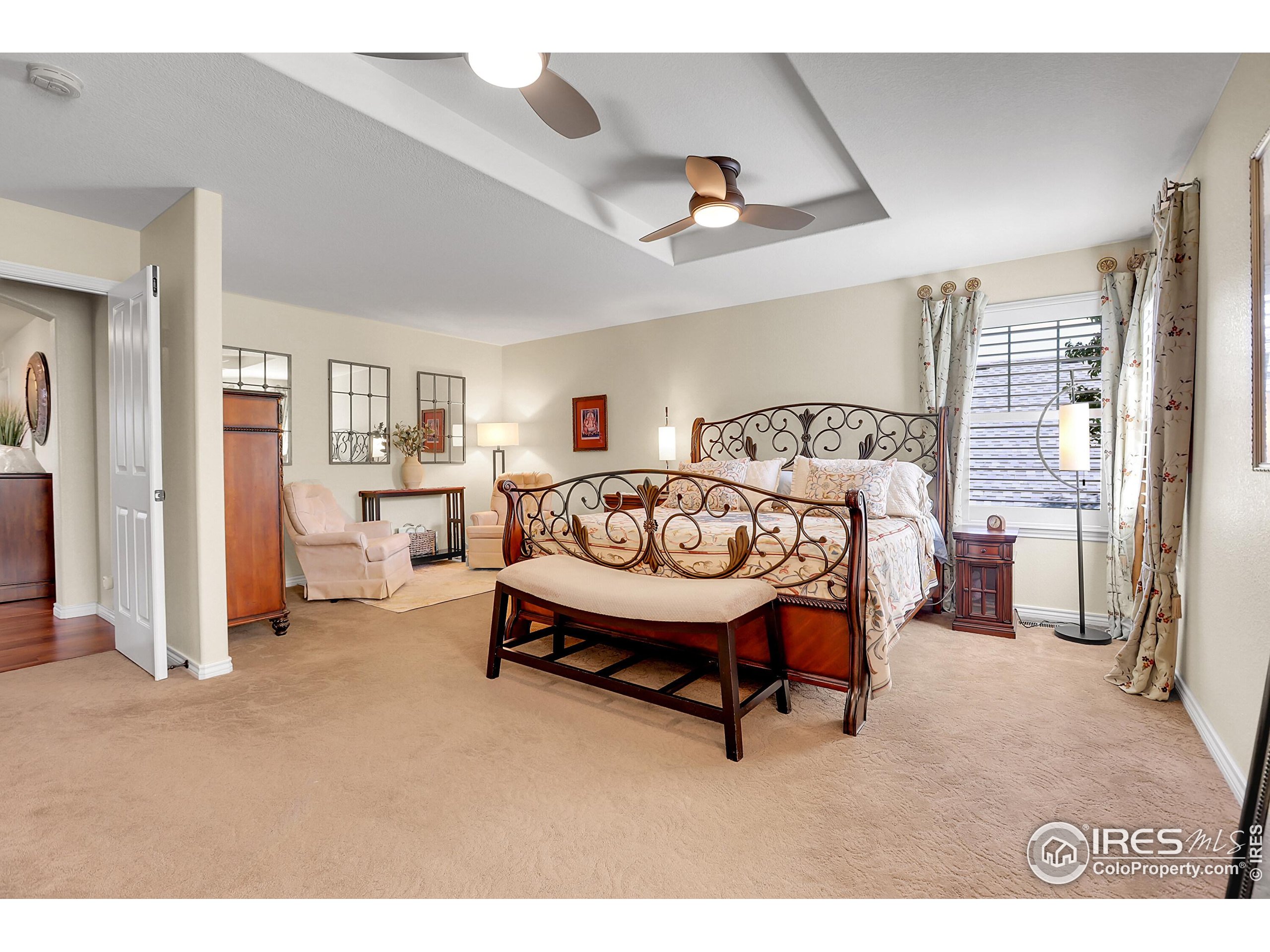 112 Austin Avenue Erie, CO 80516 - Photo 25 of 44 a spacious bedroom with a bed and a large mirror