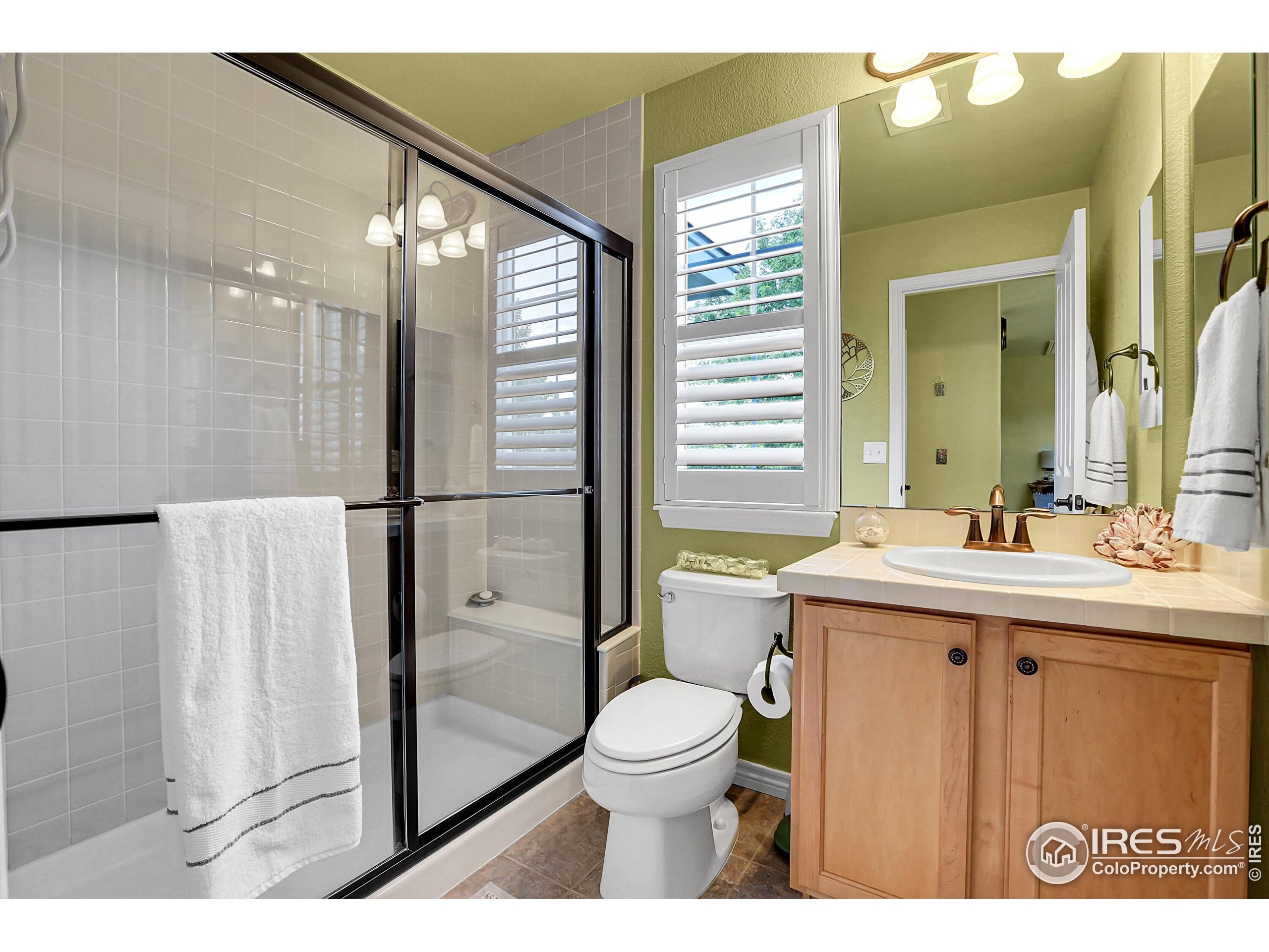 112 Austin Avenue Erie, CO 80516 - Photo 33 of 44 a bathroom with a granite countertop sink toilet a mirror and shower