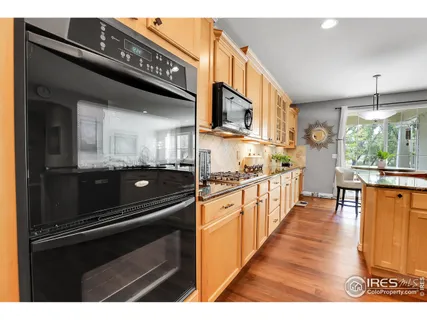 a open kitchen with stainless steel appliances granite countertop a stove a refrigerator and a microwave