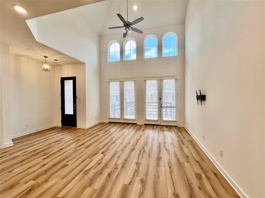 3708 Queen Road Sherman, TX 75090 - Photo 3 of 30 Empty room featuring light hardwood / wood-style floors, ceiling fan, and a towering ceiling