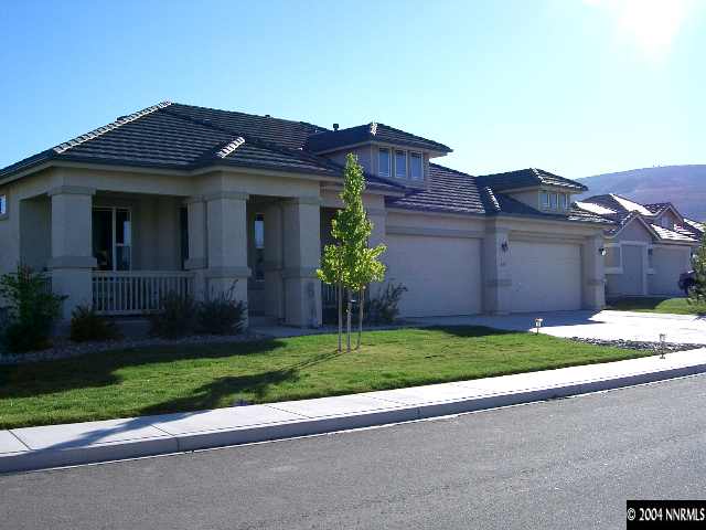 a view of a house with a yard and large tree