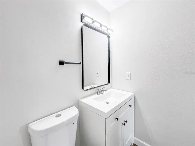 a bathroom with a sink a toilet and mirror