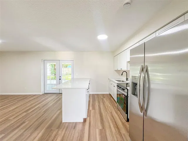 a view of a kitchen with a sink refrigerator and a window