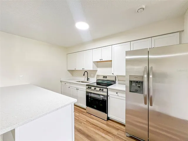 a kitchen with a stove a refrigerator and a sink