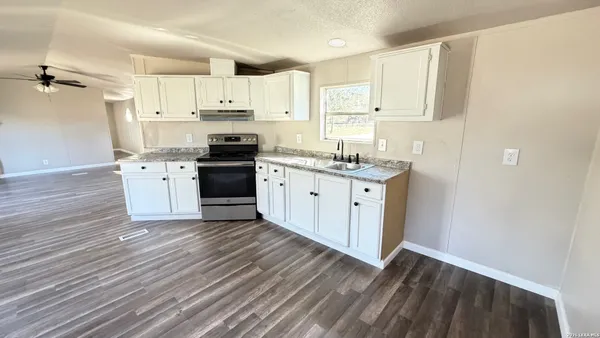 a kitchen with stainless steel appliances a stove top oven and cabinets