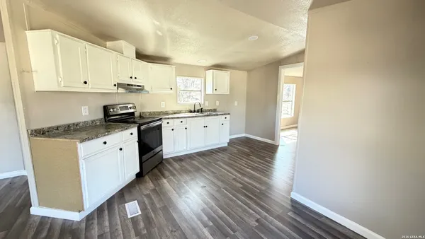 a kitchen with granite countertop white cabinets and white appliances