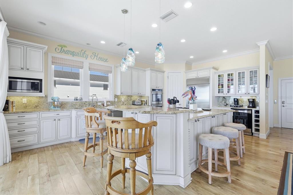 131 South Gulf Boulevard Boca Grande, FL 33921 - Photo 22 of 59 a kitchen with a dining table chairs wooden floor cabinets and stainless steel appliances