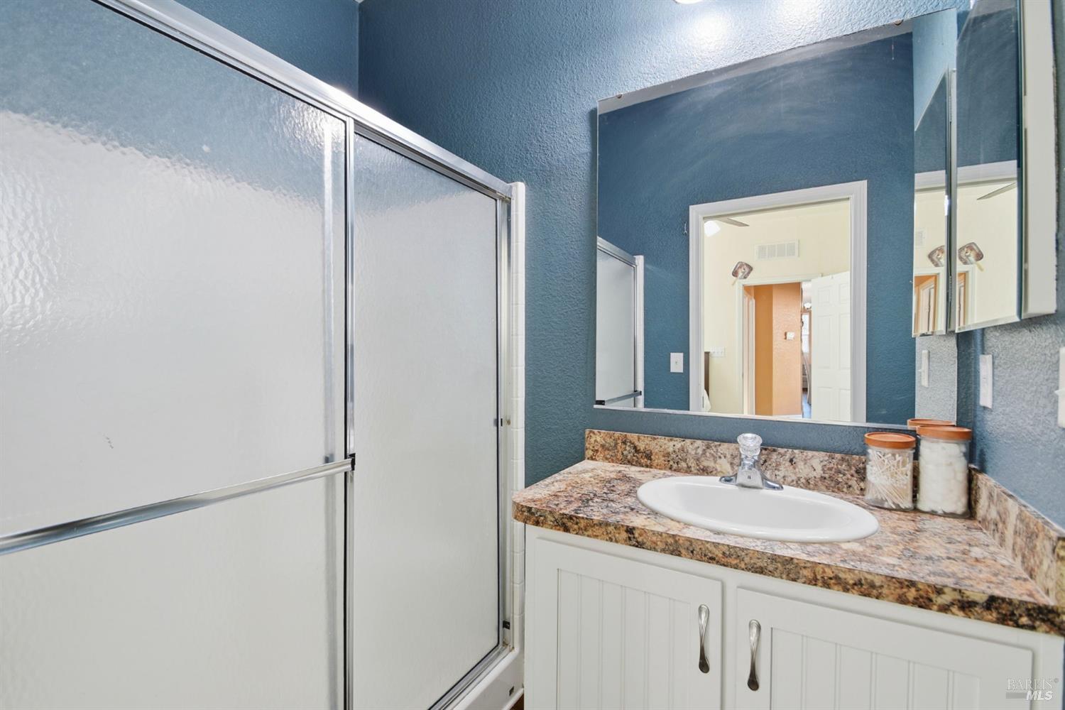 5501 Ranchito Way Santa Rosa, CA 95403 - Photo 17 of 20 a bathroom with a granite countertop sink and a mirror