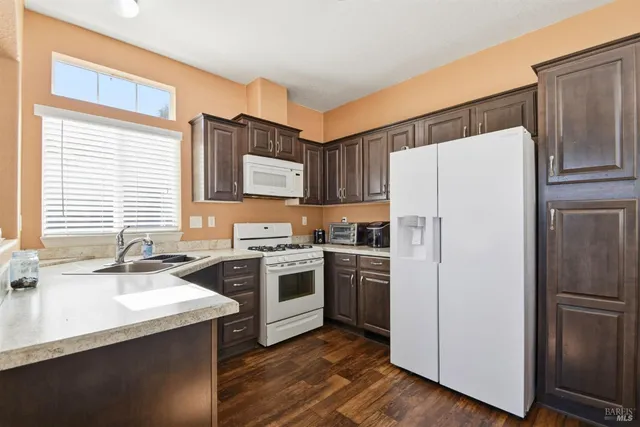 a kitchen with stainless steel appliances a refrigerator a sink and wooden cabinets