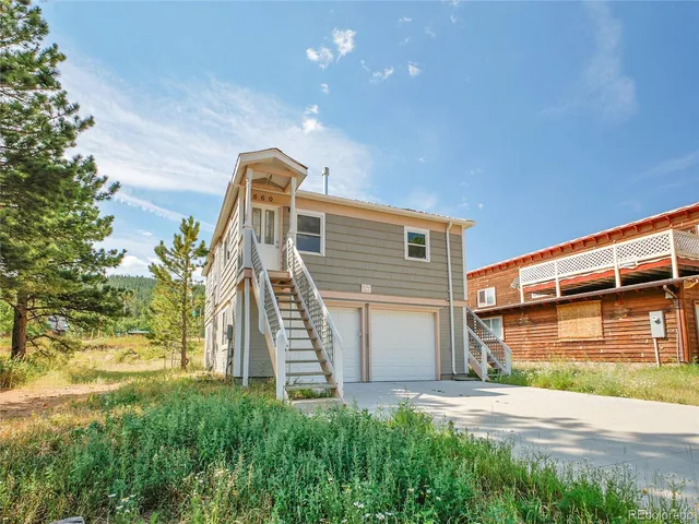 a view of a house with a yard and garage
