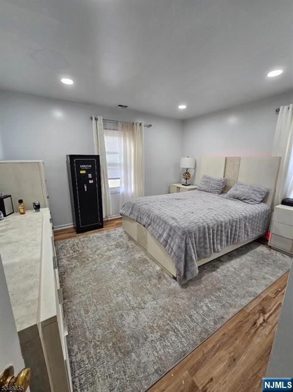 120 Sherwood Avenue, Unit 102 Paterson, NJ 07502 - Photo 9 of 13 a bedroom with a bed and wooden floor