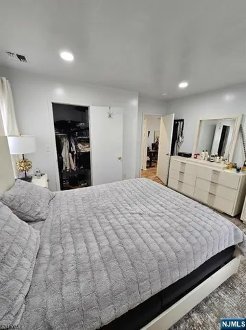 a bedroom with a large bed and wooden floor