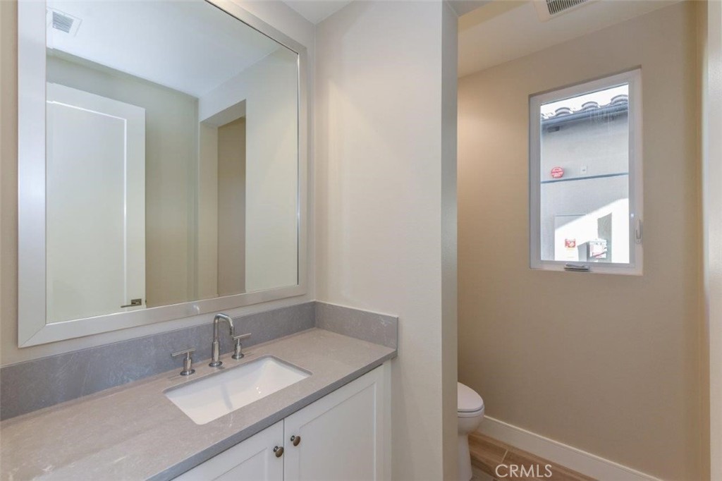 102 Winnett Irvine, CA 92602 - Photo 8 of 9 a bathroom with a granite countertop sink toilet and mirror
