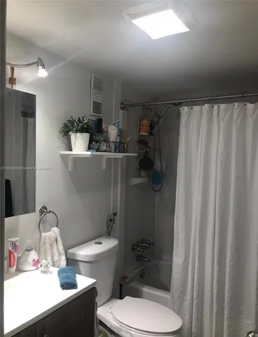 a bathroom with a sink a toilet and shower curtain
