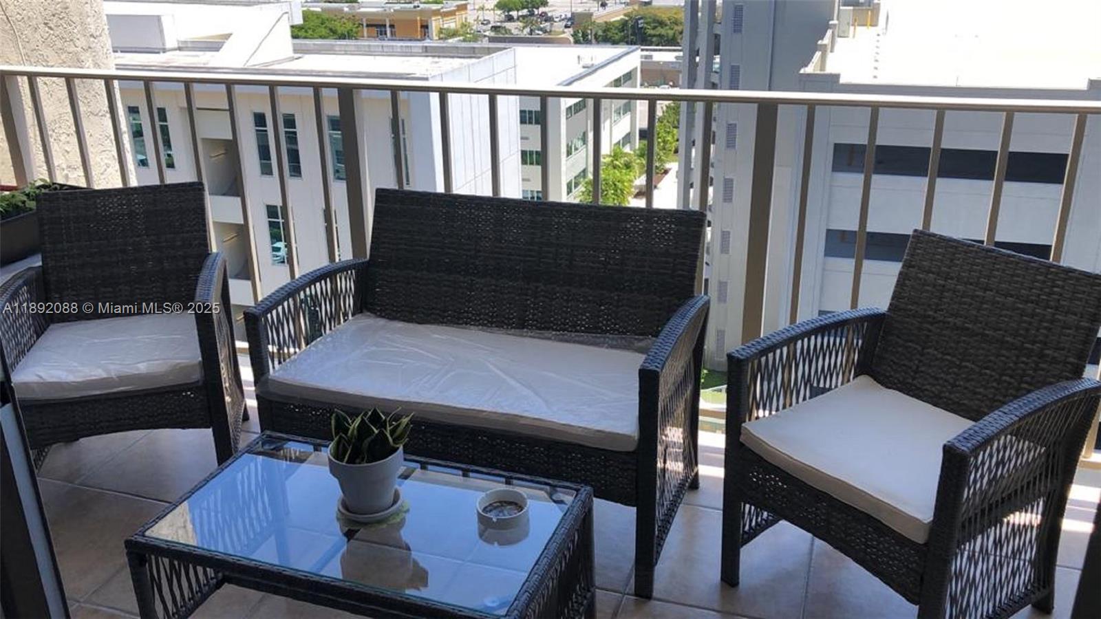 4675 West 18th Court, Unit 1011 Hialeah, FL 33012 - Photo 15 of 16 a view of balcony with wooden floor and outdoor seating