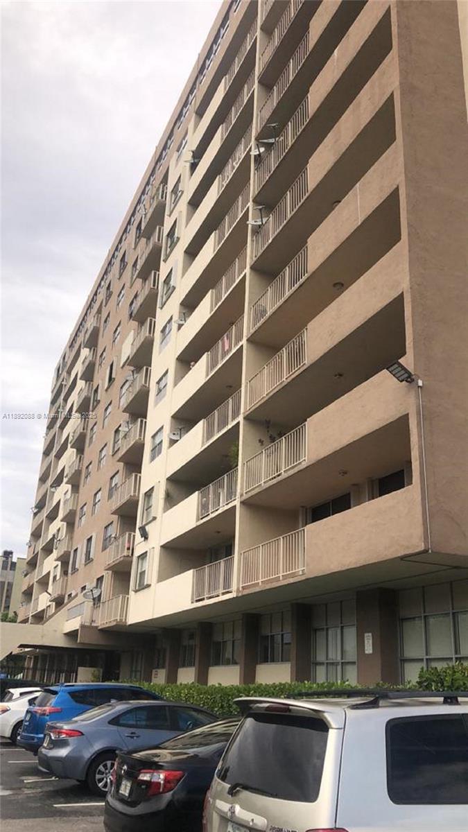 4675 West 18th Court, Unit 1011 Hialeah, FL 33012 - Photo 16 of 16 a front view of a building with parking space