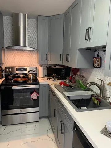 a kitchen with stainless steel appliances granite countertop a sink and a stove