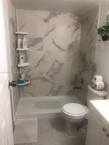 a bathroom with a toilet and a shower