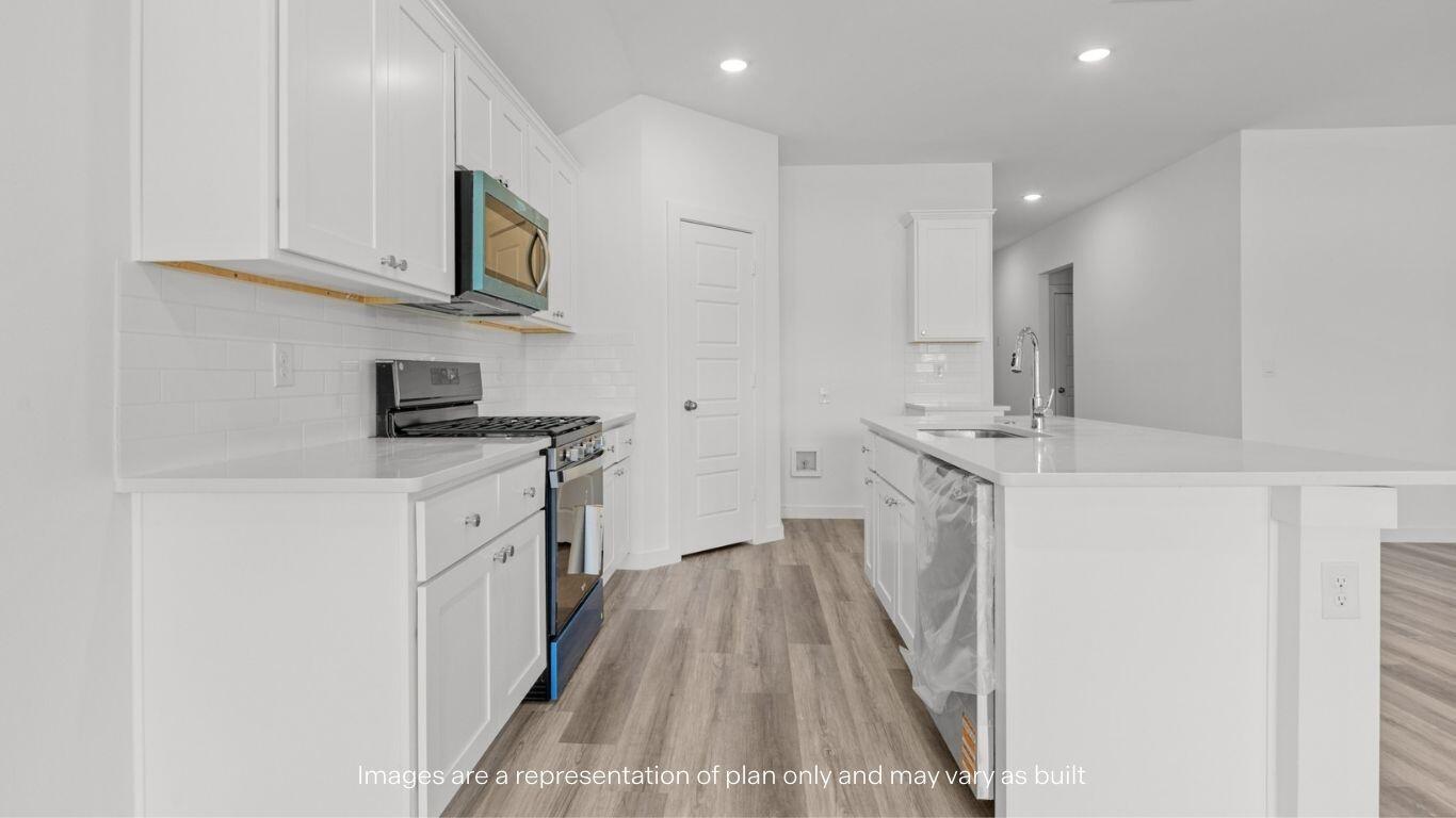 7411 9th Street Lubbock, TX 79416 - Photo 4 of 20 a kitchen with white cabinets sink and stainless steel appliances